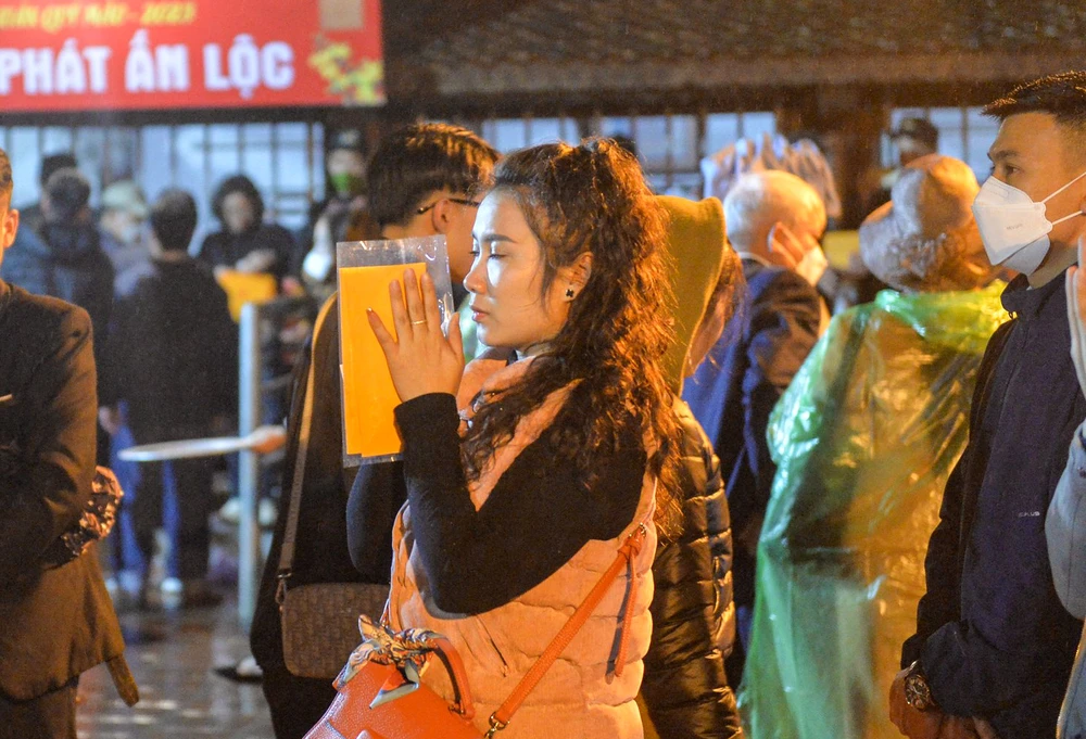 Một du khách nhận ấn đền Trần sau gần 5 tiếng chờ đợi. Ảnh: ĐT