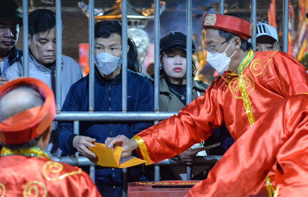 Nhiều người dân du khách đội mưa trong đêm khai ấn để nhận ấn lúc 5g sáng ngày 5-2. Ảnh: ĐT