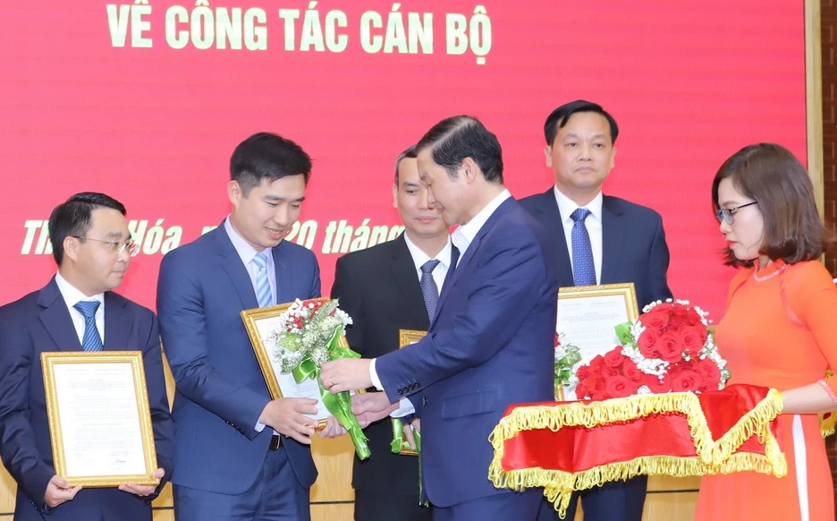 Ông Đỗ Minh Tuấn, Chủ tịch UBND tỉnh Thanh Hóa, tặng hoa chúc mừng các cán bộ nhận nhiệm vụ mới. Ảnh: MINH HIẾU