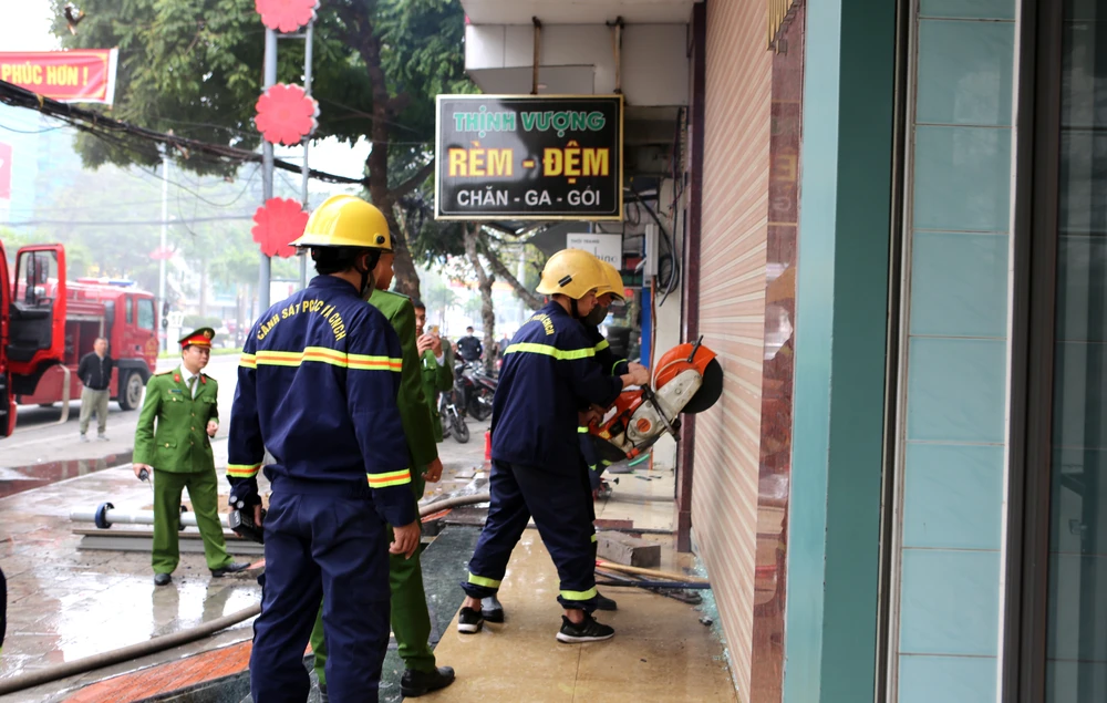 Trong khi đó, các chiến sĩ cũng sử dụng các công cụ để phá cửa cuốn khống chế đám cháy, cứu người. Ảnh: ĐẶNG TRUNG