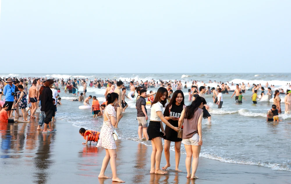 Trên bờ biển Sầm Sơn, một nhóm bạn trẻ hào hứng xuống biển tranh thủ lựa chọn điểm đứng để check - in. Ảnh: ĐẶNG TRUNG