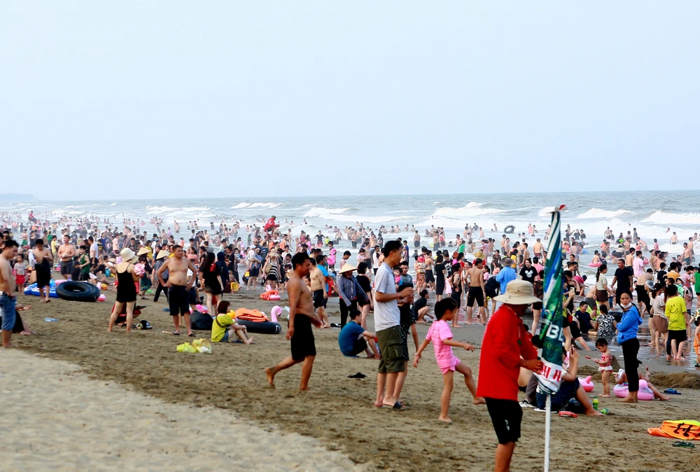 Khoảng 16g chiều ngày 6-5, du khách bắt đầu đổ xuống biển, nhưng chỉ khoảng 30 phút sau thì bờ biển dài của Sầm Sơn đã kín người tắm biển. Ảnh: ĐẶNG TRUNG