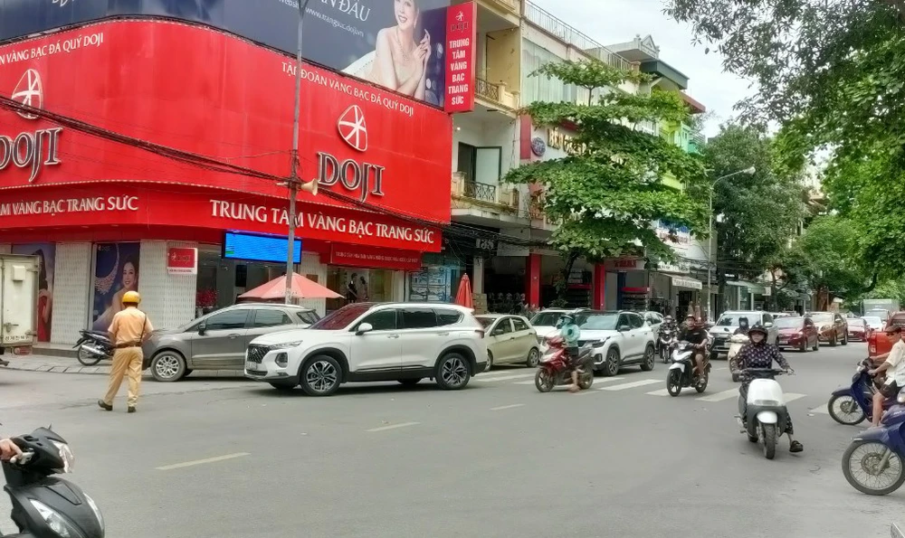 Cảnh sát giao thông hướng dẫn các phương tiện trên phố Lê Hoàn.