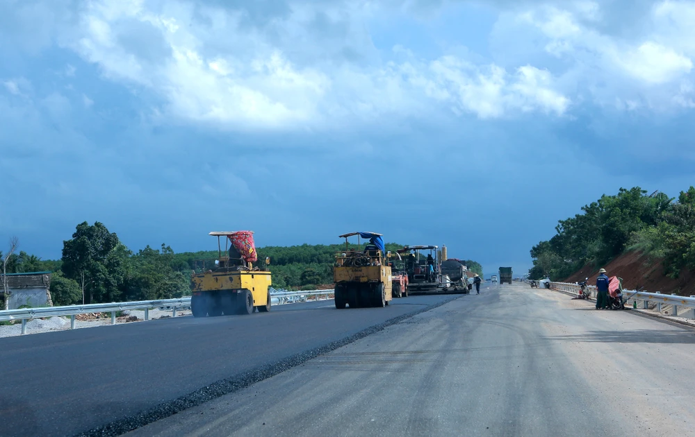 Các công nhân đang tiến hành thảm nhựa mặt đường. Ảnh: ĐẶNG TRUNG