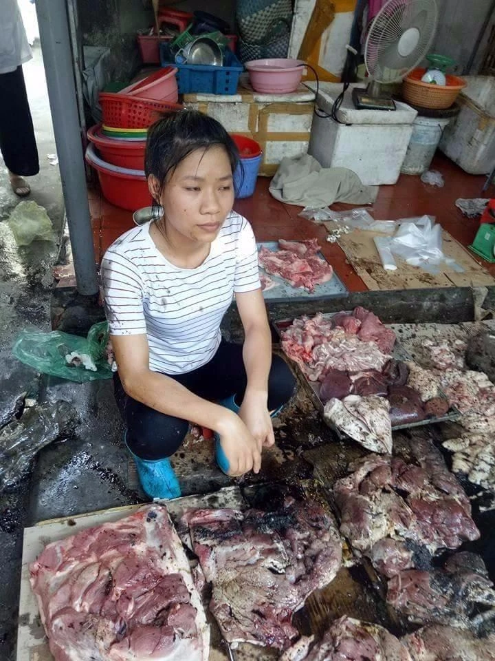 Người phụ nữ với phản thịt lợn bị đổ luyn và chất thải.