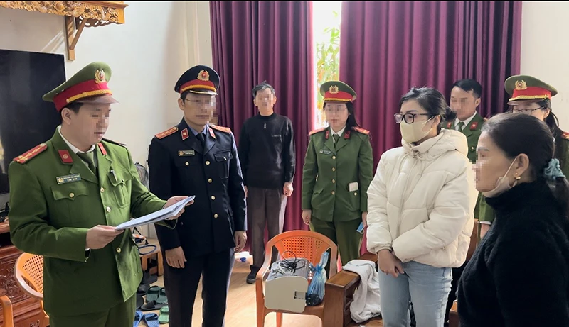 Cơ quan công an tống đạt quyết định khởi tố đối với Nguyễn Hà Linh (áo trắng). Ảnh: CA