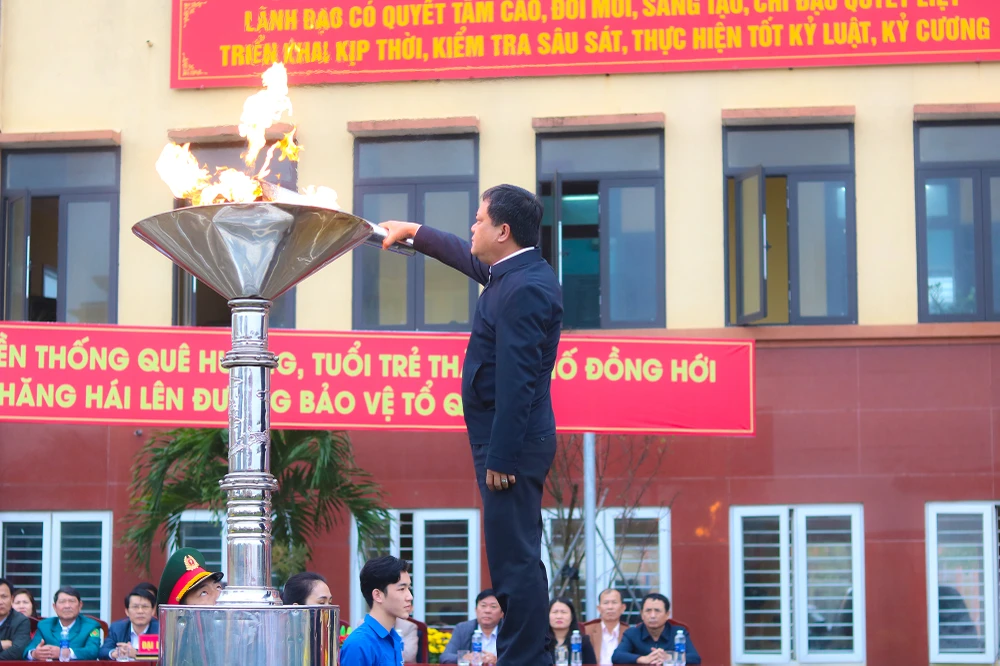 Ông Trần Phong, Bí thư Thành uỷ Đồng Hới, thắp lửa truyền thống tại lễ giao nhận quân. Ảnh: BT