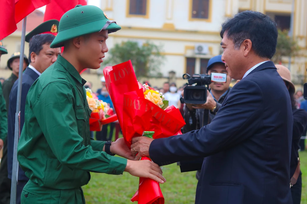 Ông Đoàn Ngọc Lâm, Phó Chủ tịch Thường trực UBND tỉnh Quảng Bình tặng hoa chúc mừng các tân binh. Ảnh: BT
