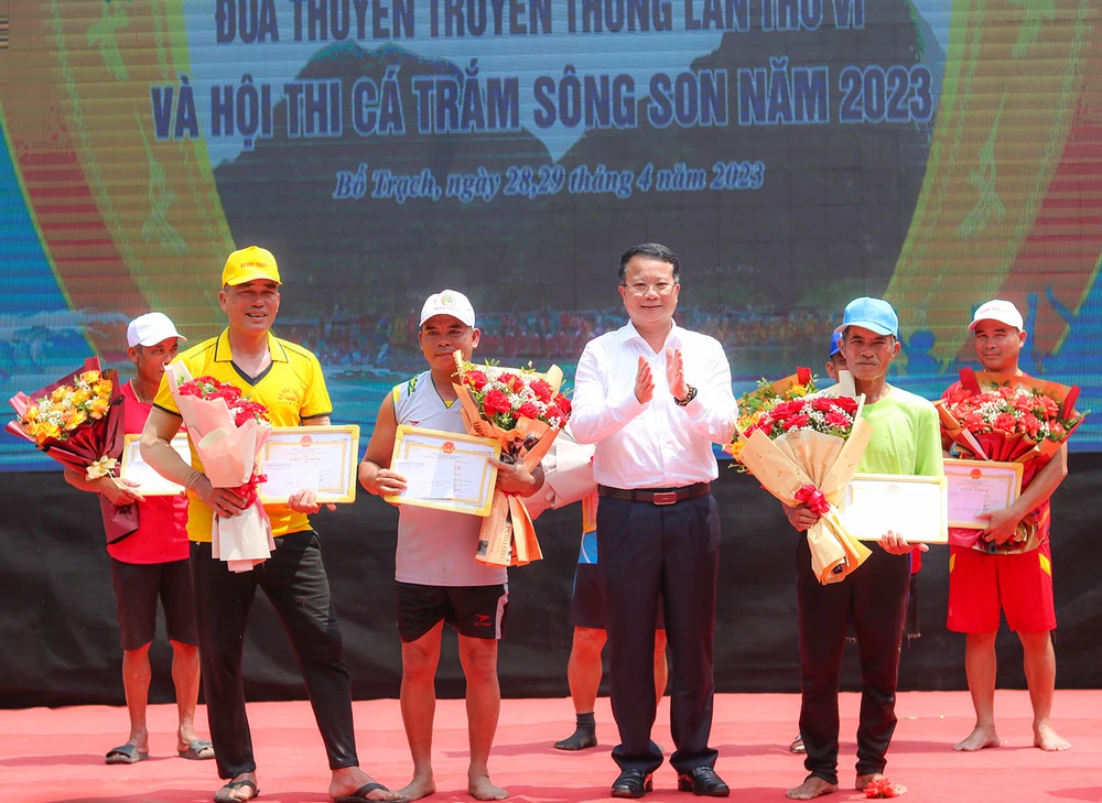 Ông Nguyễn Hữu Hồng, Phó Chủ tịch UBND huyện Bố Trạch trao giải cho đại diện các thuyền đua. Ảnh: BẢO THIÊN