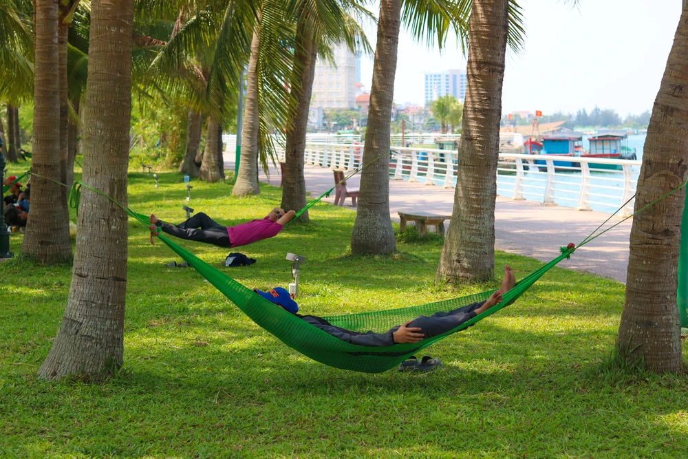 Nhiều người lao động trốn nắng trong các công viên dọc sông Nhật Lệ. Ảnh: BẢO THIÊN