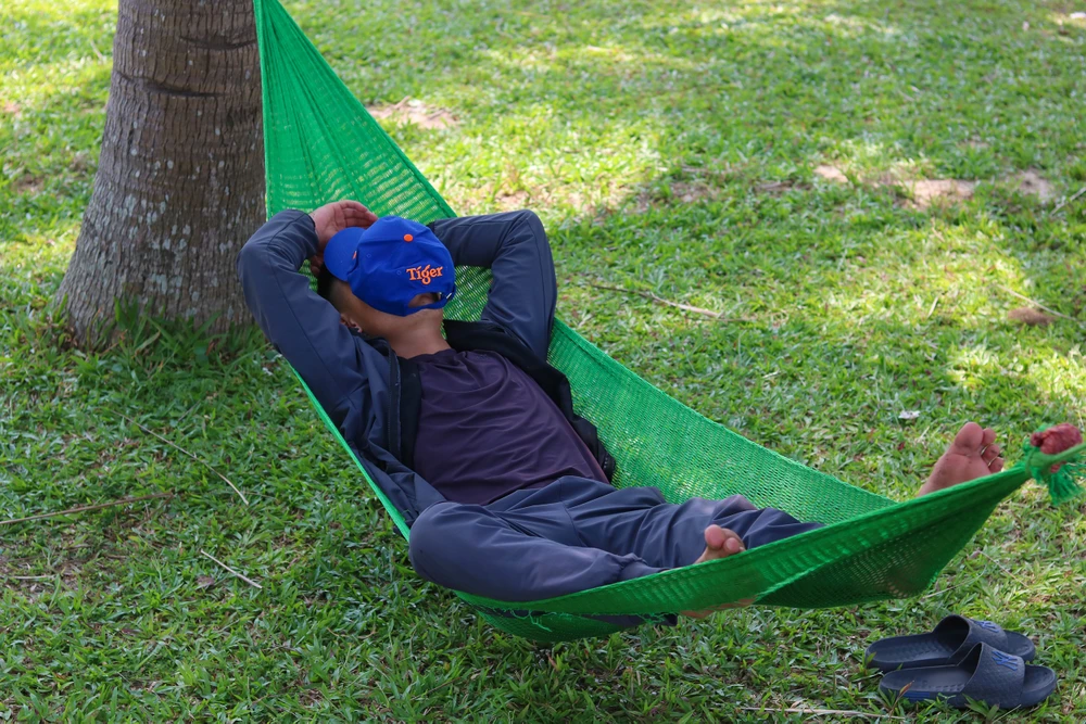 Một người lao động nghỉ ngơi giờ trưa ở công viên Đồng Mỹ. Ảnh: BẢO THIÊN