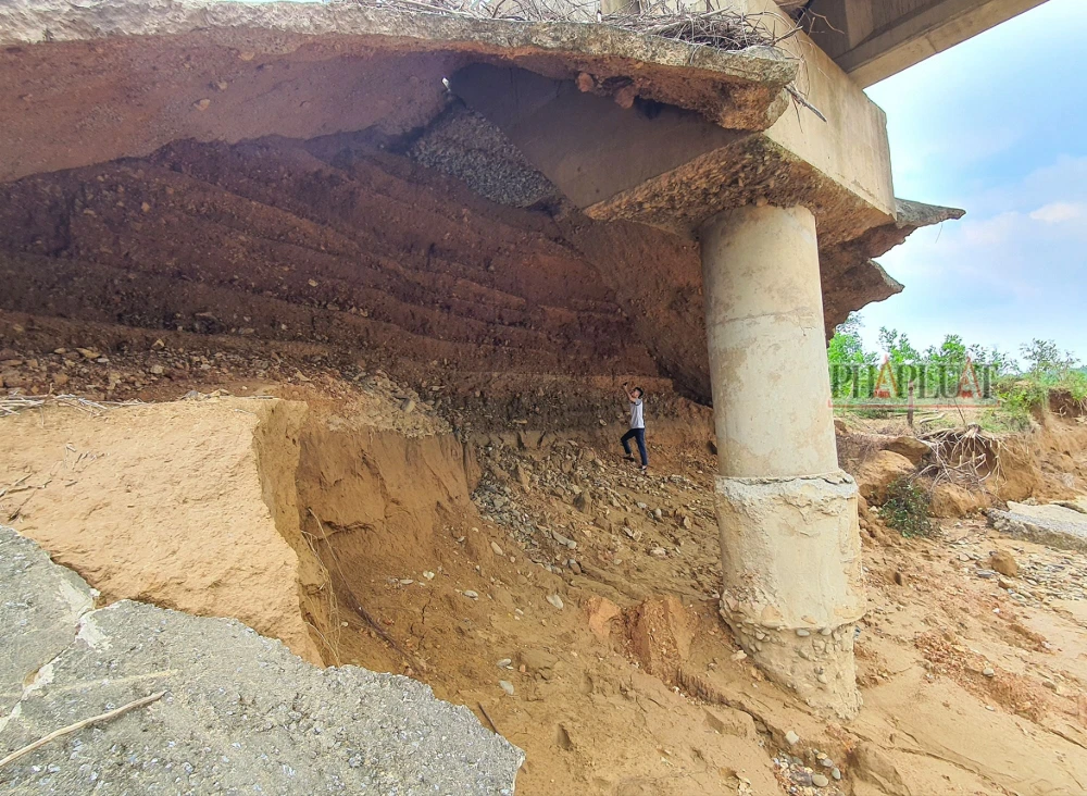 Một lượng đất đá ở phần trụ cầu phía giáp với bản Chuôn bị xói lở nghiêm trọng khiến mố cầu hở toác. Ảnh: B.THIÊN