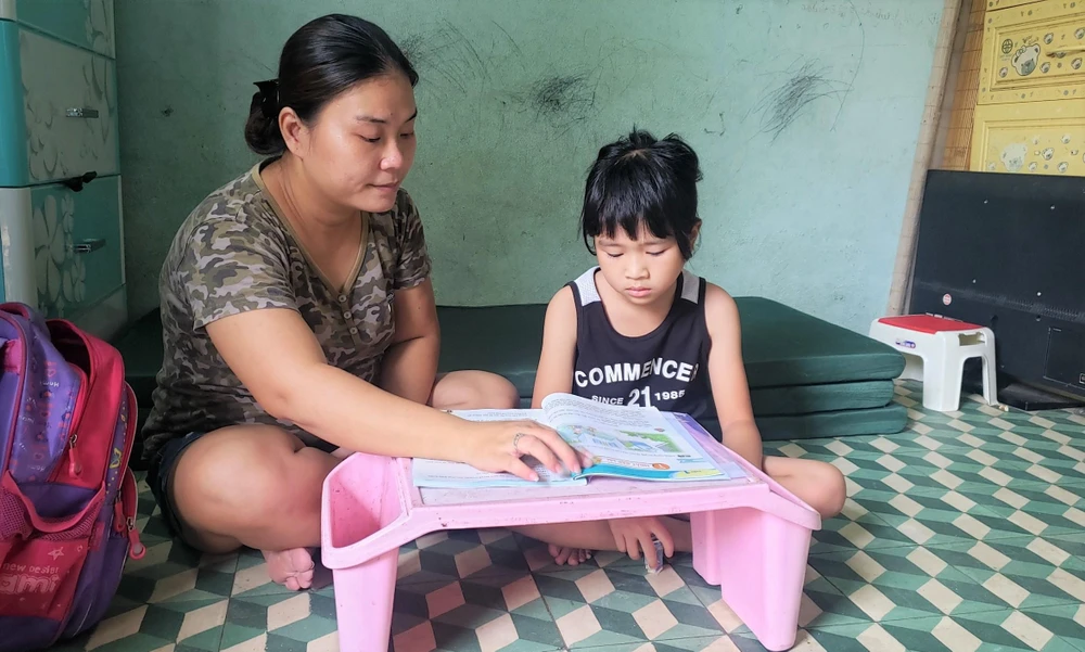 Chị Na kèm con gái ôn bài. Ảnh: T.AN
