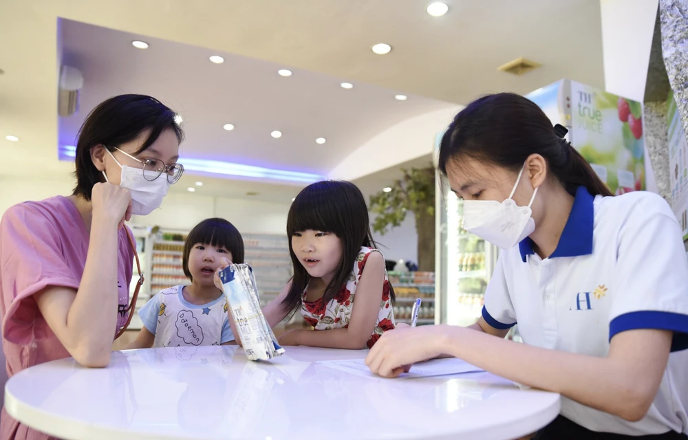 Một khách hàng đưa các con đi cùng đến đổi vỏ hộp sữa tại TH true mart