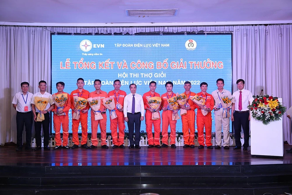 Ông Ngô Sơn Hải, Phó Tổng giám đốc EVN (đứng giữa) và lãnh đạo các ban chuyên môn thuộc EVN tặng kỷ niệm chương cho các thí sinh đạt danh hiệu “Thợ giỏi EVN năm 2022”.
