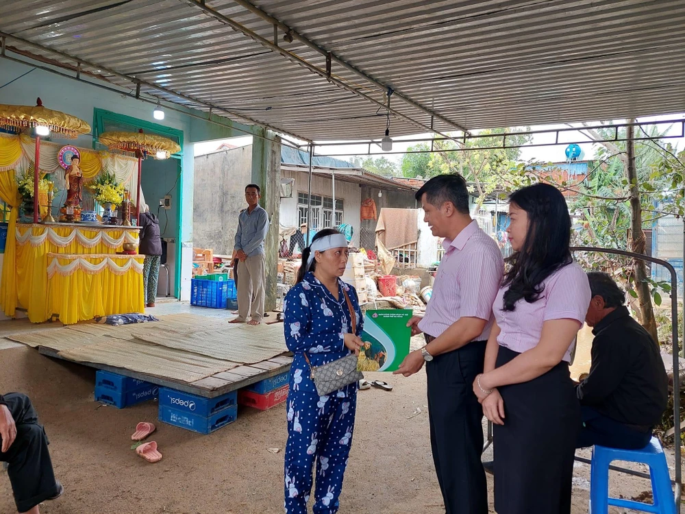Ông Đoàn Ngọc Chung, Giám đốc Chi nhánh NHCSXH TP Đà Nẵng và lãnh đạo công đoàn cơ sở thăm hỏi gia đình có người mất trong mưa lũ vào tối 14-10.