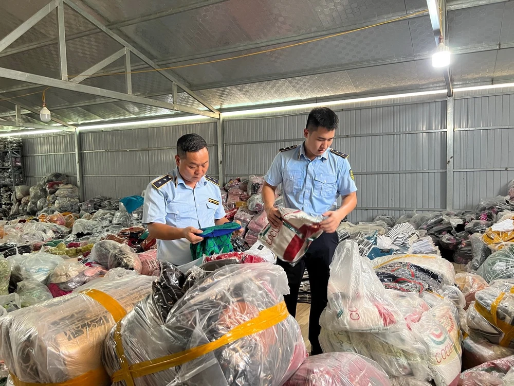 Lực lượng quản lý thị trường kiểm đếm hàng hóa giả mạo nhãn hiệu, nhập lậu thu giữ được tại một tổng kho ở Tuyên Quang. Ảnh: QLTT