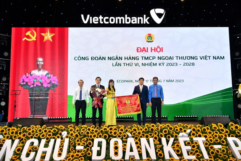 Đ/c Huỳnh Thanh Xuân – Phó Chủ tịch Tổng Liên đoàn Lao động Việt Nam (ngoài cùng bên phải) tặng Cờ Thi đua của Tổng Liên đoàn Lao động Việt Nam và đ/c Đỗ Việt Hùng – Phó Bí thư thường trực Đảng ủy Vietcombank (ngoài cùng bên trái) tặng hoa cho đại diện Công đoàn Vietcombank