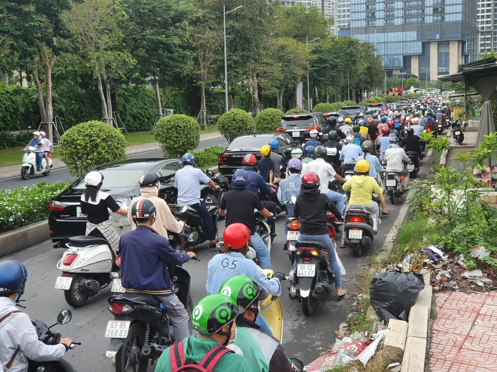 Xe nối đuôi nhau hàng dài hướng vào khu dân cư để vào đường Nguyễn Hữu Cảnh.