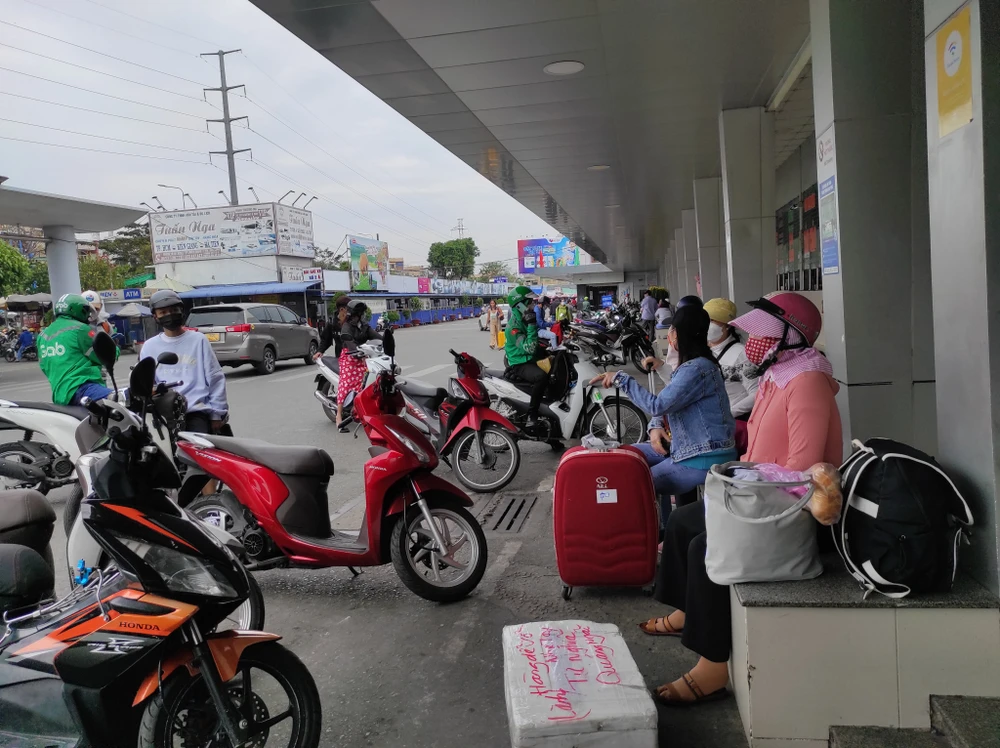 Ở khu vực bến xe miền Tây, nhiều người dân tay xách nách mang đang bắt grab về nhà.
