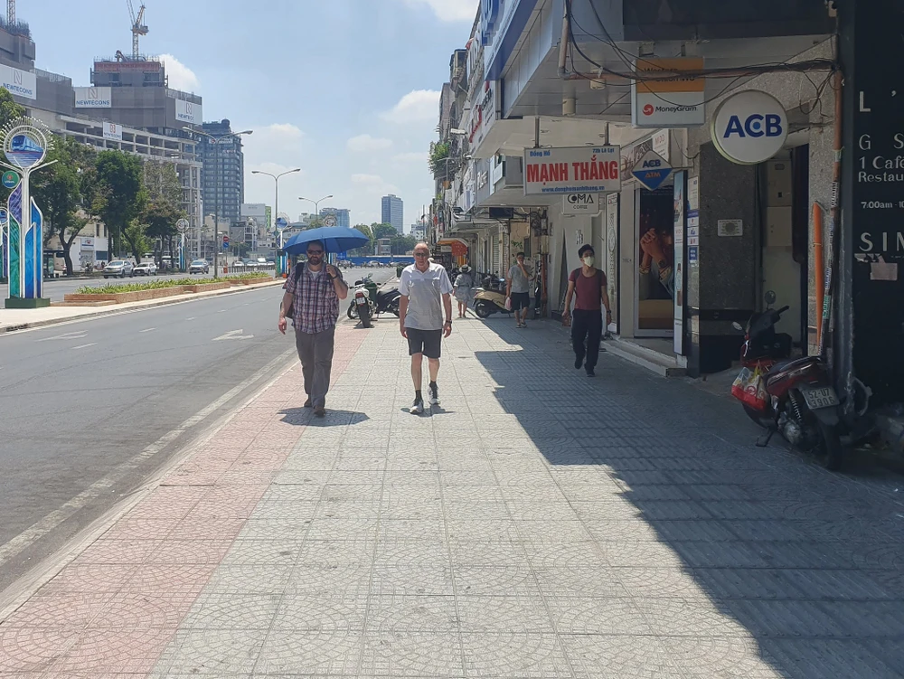 Có du khách chọn cách mang theo dù khi tản bộ qua đây.