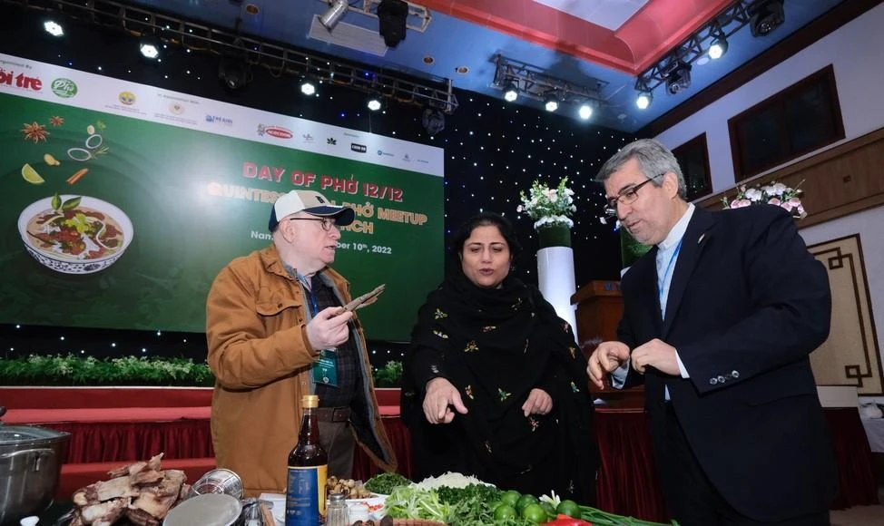 Đại sứ Pakistan tại Việt Nam Samina Mehtab (trái) và Đại sứ Iran tại Việt Nam Ali Akbar Nazari (phải) tìm hiểu về nguyên liệu nấu phở tại sự kiện. Ảnh: TTO.