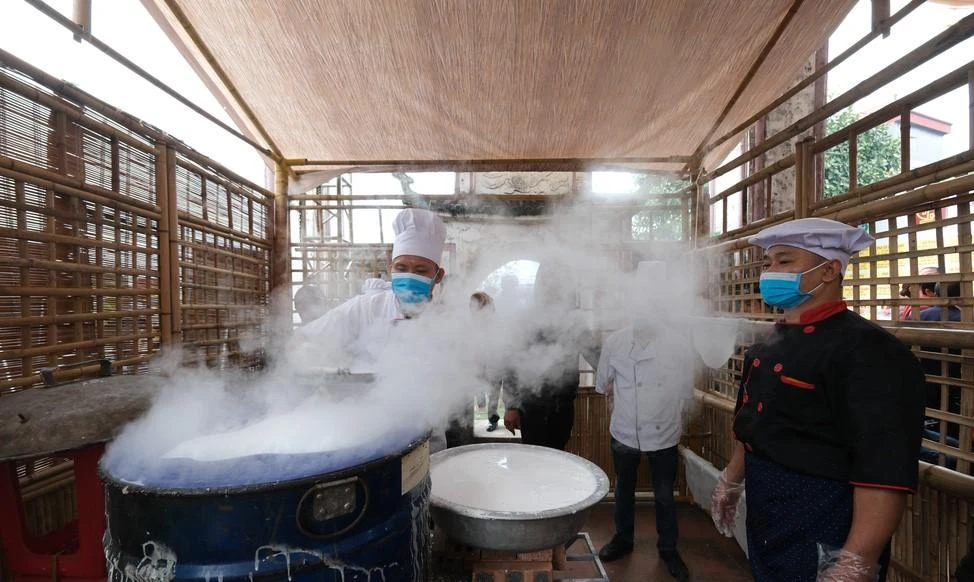 Người làng Vân Cù biễu diễn kỹ thuật tráng bánh cổ truyền. Ảnh: TTO.