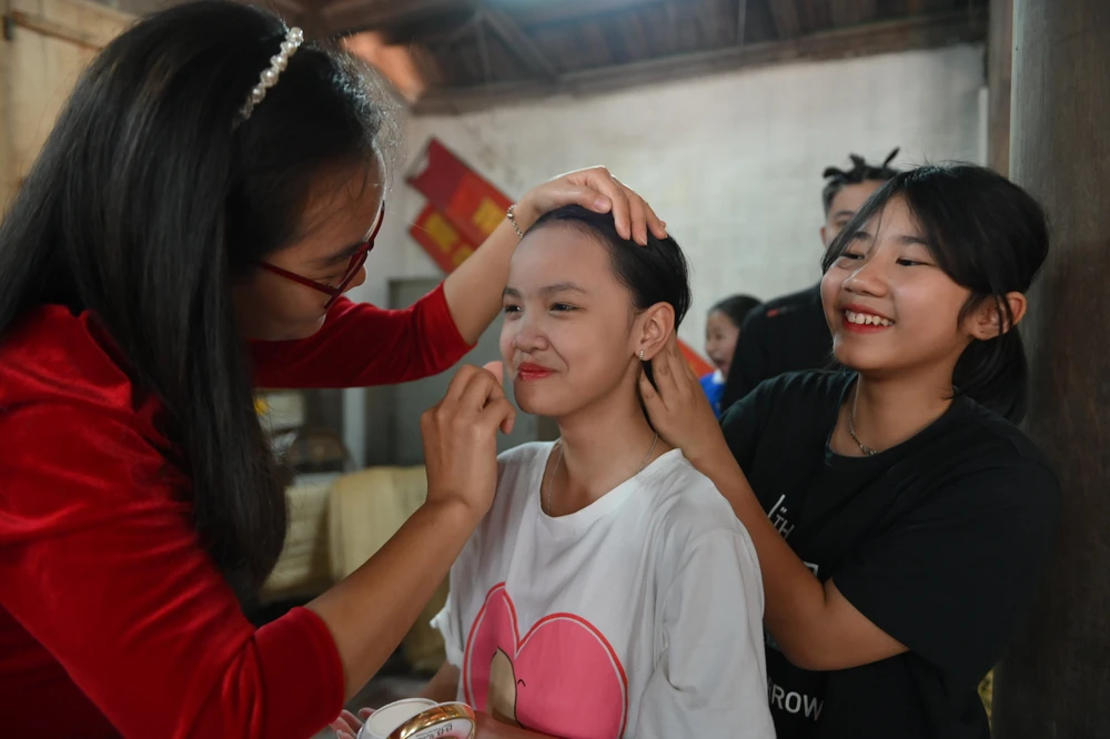 Các em nhỏ trang điểm kỹ càng, chuẩn bị cho màn múa tích "cởi vú mo". ẢNH: HOÀNG ANH