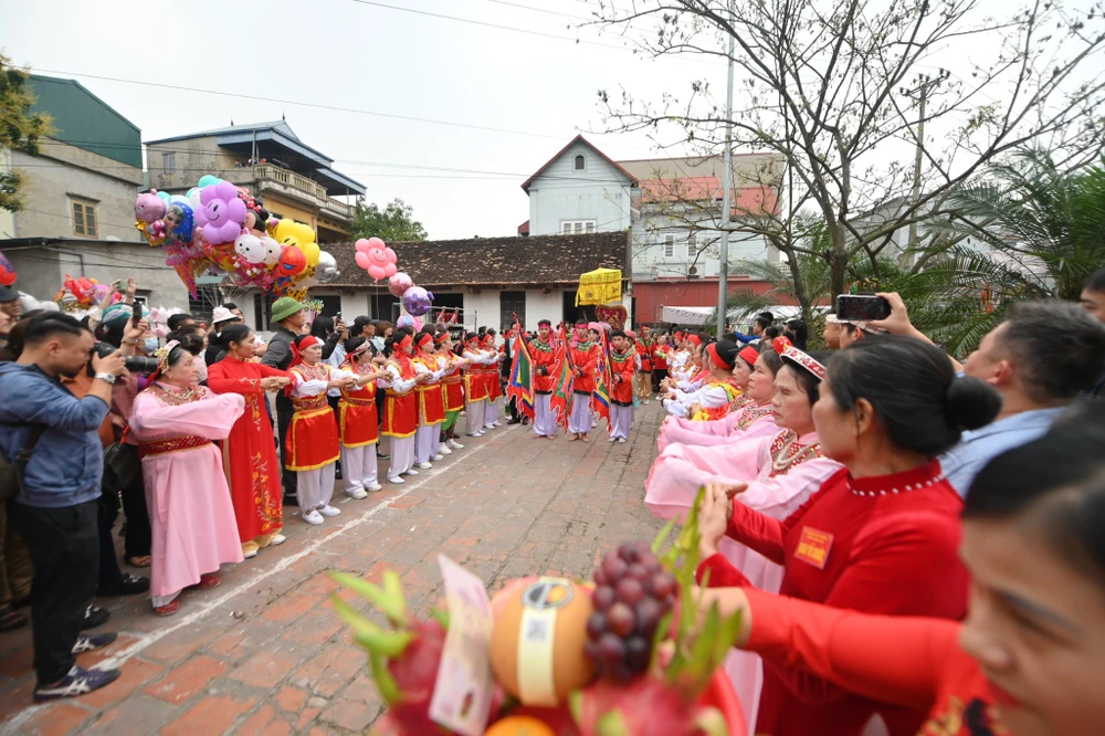Mở đầu là màn vinh quy bái tổ. Một đoàn người rước kiệu đi từ cổng làng vào sân đình, hai bên có các bô lão trong làng đón Thánh bà xuống kiệu. ẢNH: HOÀNG ANH