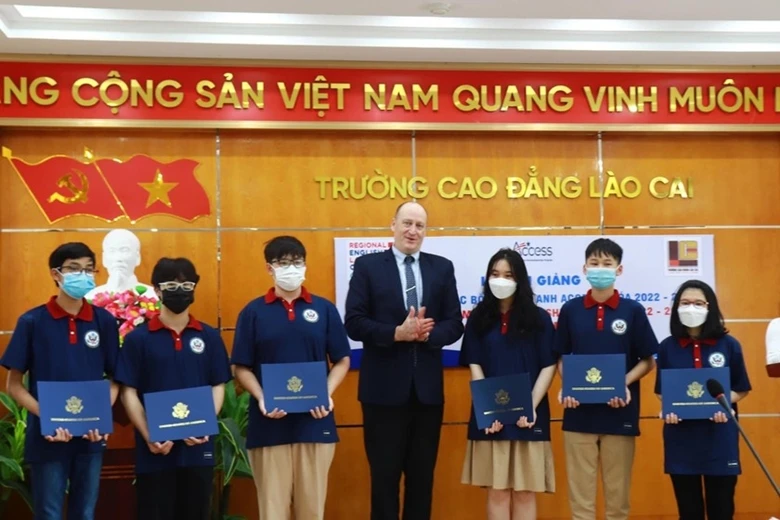 Ông Jerrold Frank, Giám đốc Văn phòng Tiếng Anh Khu vực trao giấy chứng nhận trúng tuyển cho các em học sinh vào tháng 4-2022. Ảnh: Hải Nguyễn