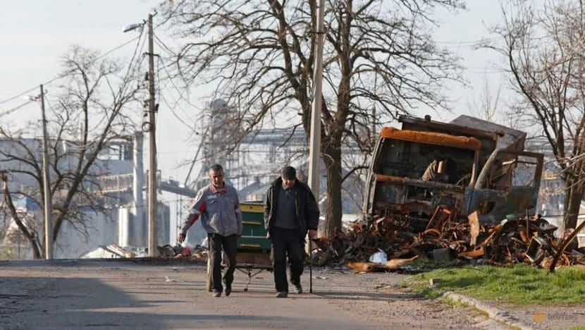 Người dân Ukraine đi lại ở phía nam thành phố Mariupol hôm 20-4. Ảnh: REUTERS
