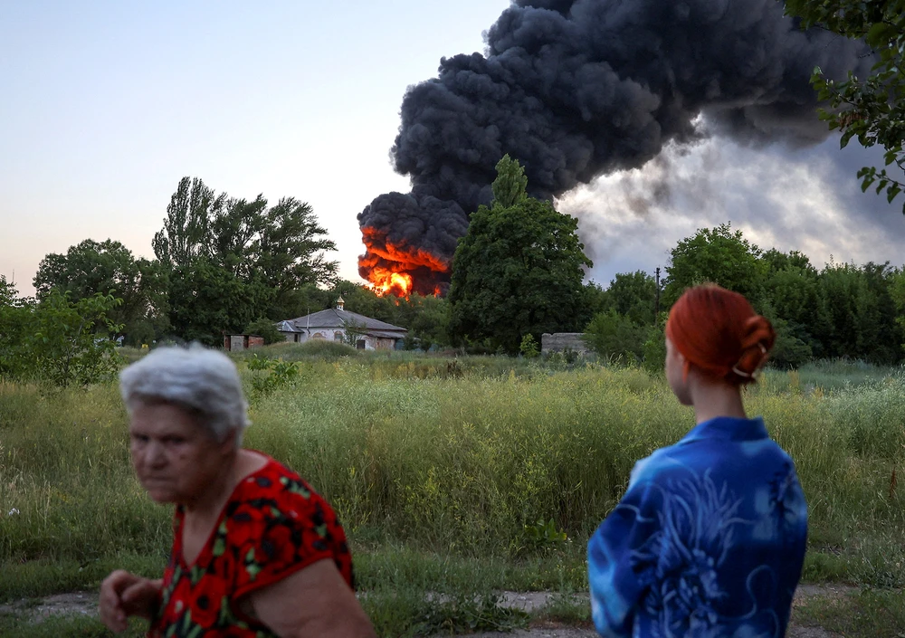 Người dân ở tỉnh Donetsk chứng kiến một vụ cháy do giao tranh Nga - Ukraine. Ảnh: REUTERS