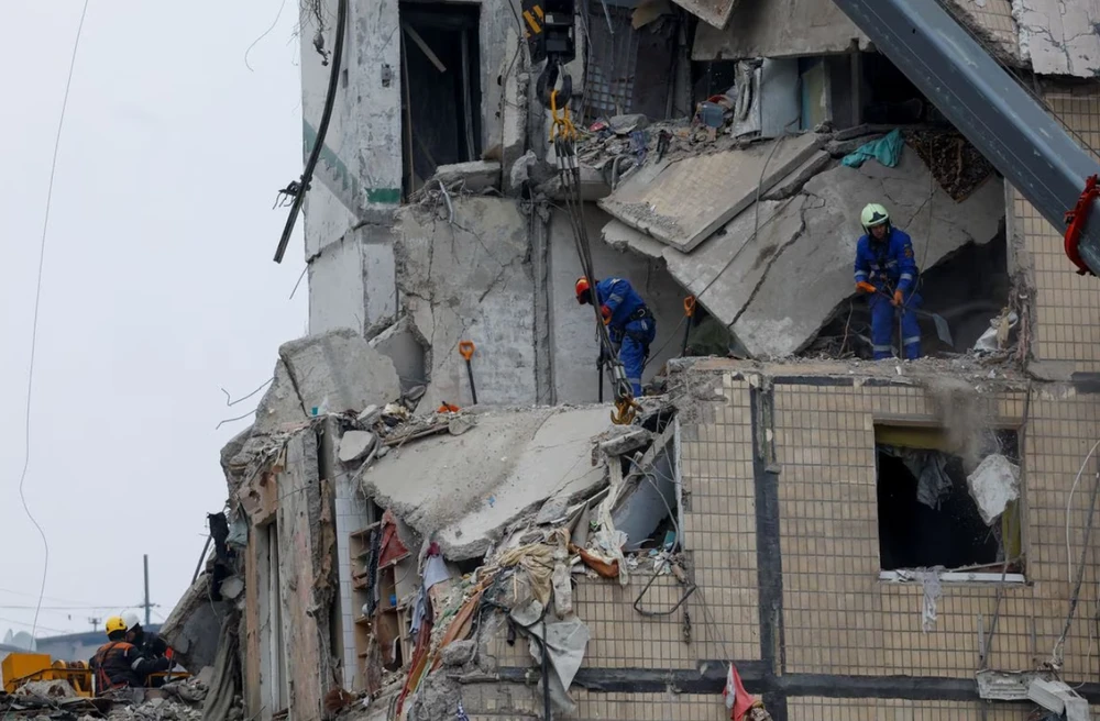 Lực lượng cứu hộ làm việc tại hiện trường bị Nga pháo kích ở TP Dnipro vào ngày 16-1. Ảnh: REUTERS