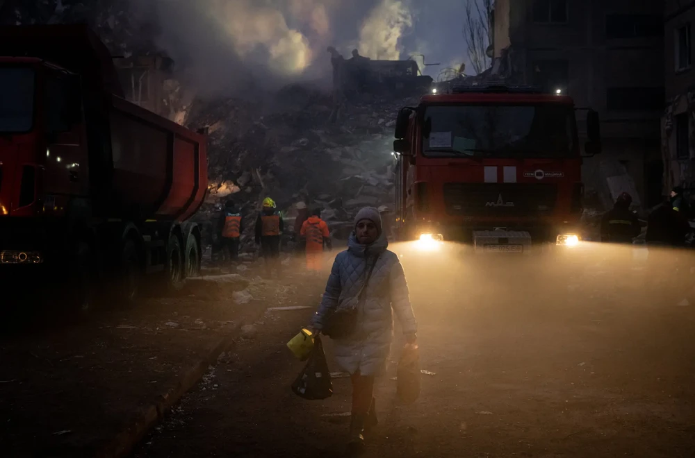 Người dân đi qua khu vực đổ nát do pháo kích ở TP TP Dnipro vào ngày 15-1. Ảnh: THE NEW YORK TIMES