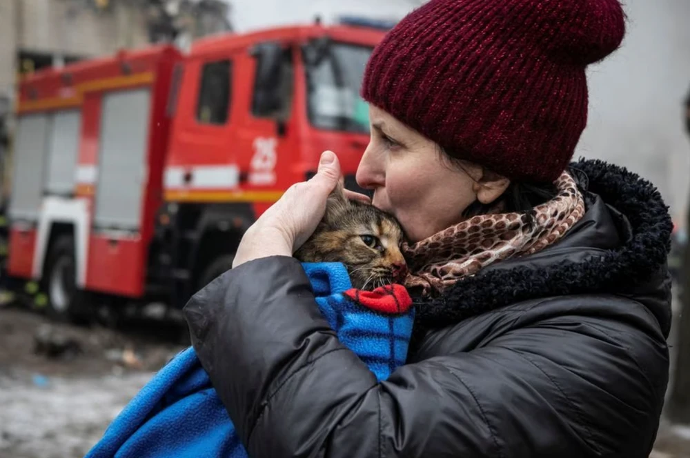 Người phụ nữ ôm con mèo của mình sau khi con mèo được giải cứu khỏi đống đổ nát do nhà pháo kích ở TP Dnipro, tỉnh Dnipropetrovsk hôm 15-1-2023. Ảnh: REUTERS