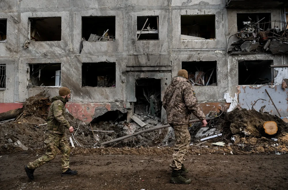 Lính Ukraine đi qua khu vực bị pháo kích ở TP Druzhkivka, tỉnh Donetsk vào ngày 5-2. Ảnh: THE NEW YORK TIMES