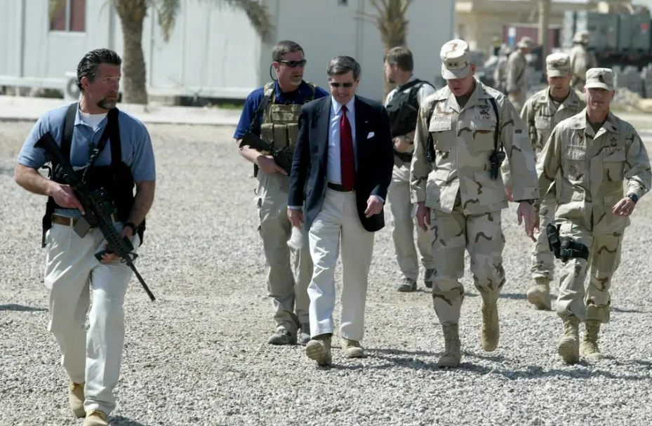 Nhân viên của Blackwater hộ tống quan chức người Mỹ Paul Bremer khi ông đến TP Ramadi (Iraq) vào tháng 3-2004. Ảnh: REUTERS