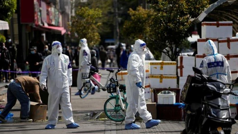 Nhân viên cảnh sát TP Thượng Hải mặc đồ bảo hộ phong tỏa các cửa hàng thực phẩm sau đợt bùng dịch hôm 29-3. Ảnh: REUTERS