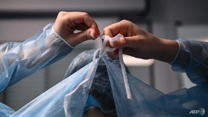 Y tế mặc thiết bị bảo hộ trước khi điều trị cho bệnh nhân COVID-19. Ảnh: AFP