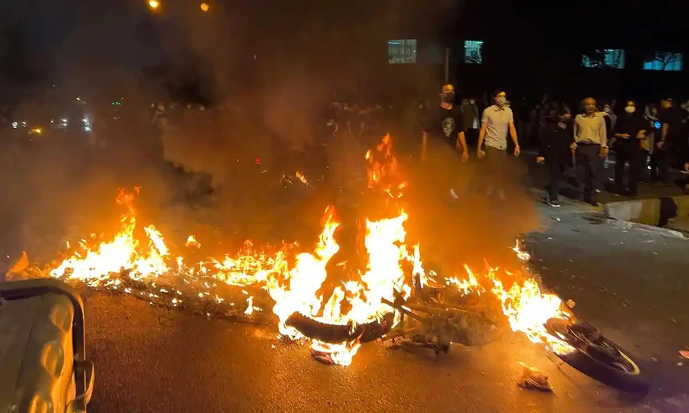Người biểu tình đốt xe cảnh sát trong cuộc biểu tình ở thủ đô Tehran ngày 19-9. Ảnh: AFP