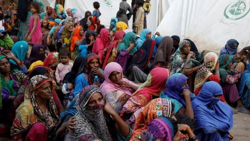 Những người phụ nữ phải di dời vì lũ lụt chờ được phát thực phẩm trong trong một trại tị nạn ở thành phố Sehwan, tỉnh Sindh, Pakistan, ngày 30-9. Ảnh: REUTERS