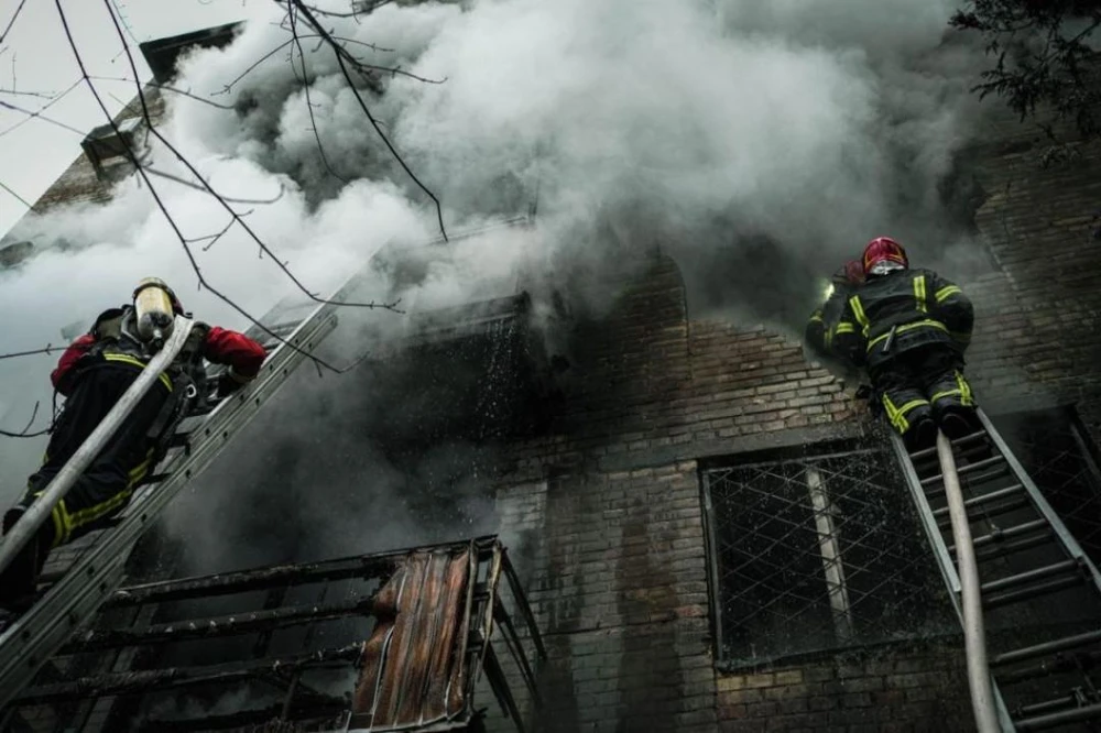 Lính cứu hỏa dập lửa sau khi hai tòa nhà dân cư ở quận Pechersk, thủ đô Kiev bị Nga pháo kích ngày 15-11. Ảnh: GETTY IMAGES