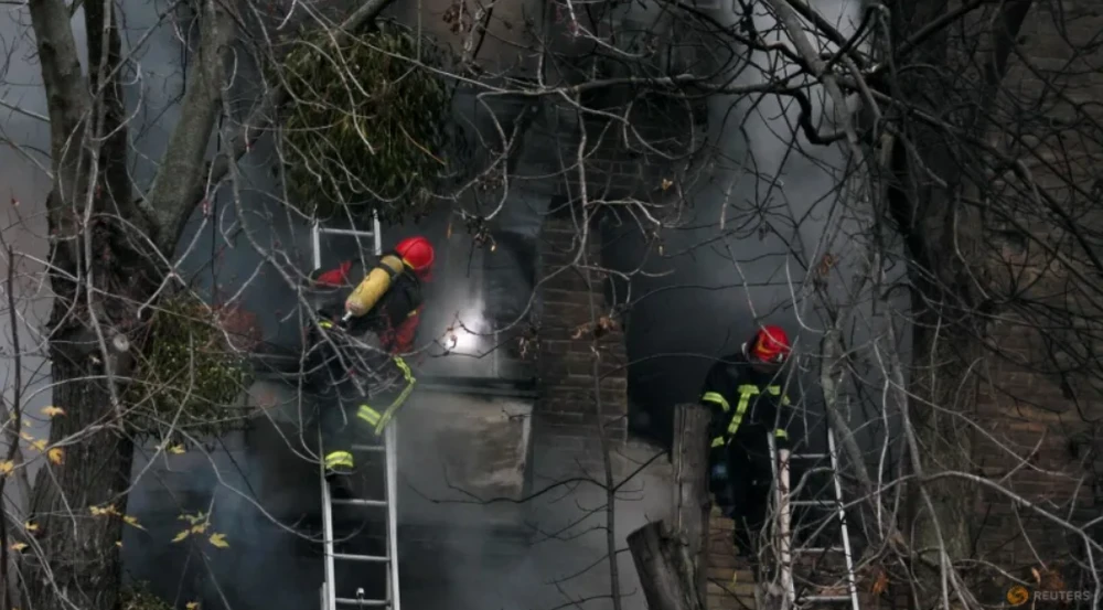 Lính cứu hỏa Ukraine dập lửa một tòa chung cư bị Nga dội tên lửa tối 15-11. Ảnh: REUTERS