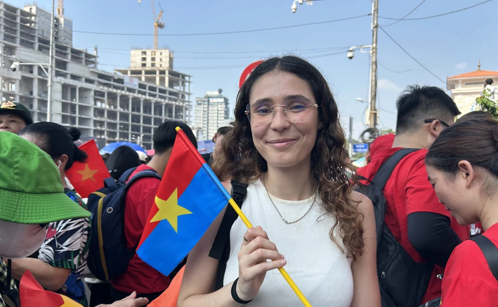 Chị Sarah (quốc tịch Pháp) xúc động khi xem các khối diễu binh ngày đại lễ 30-4. Ảnh: DƯƠNG KHANG