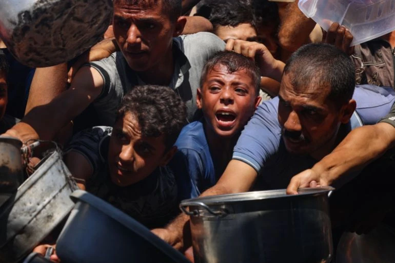 Người dân Gaza chen chúc nhận đồ ăn từ một bếp ăn từ thiện ở Khan Younis, miền nam Dải Gaza. Ảnh: AFP