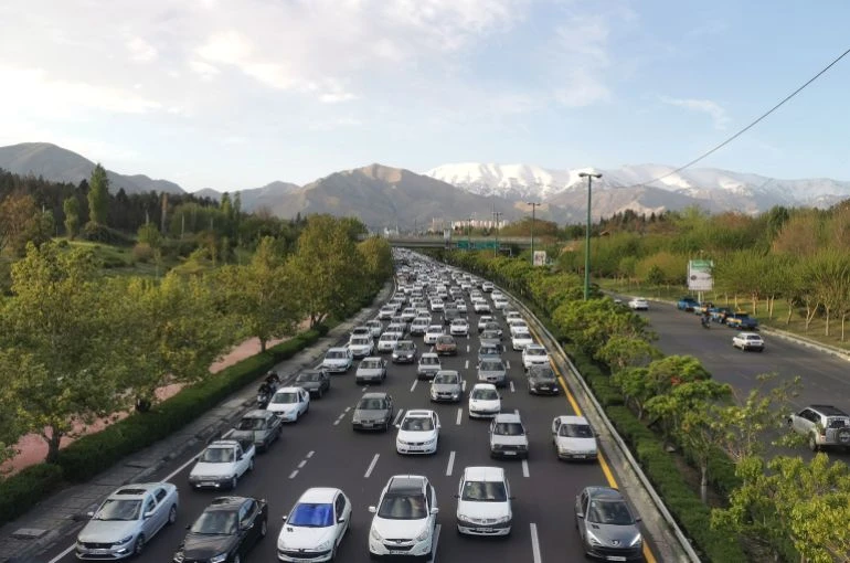 Xe cộ di chuyển trên một tuyến cao tốc, phía xa là dãy núi dãy Alborz hiện lên ở phía bắc Tehran. Ảnh: Atta Kenare/AFP