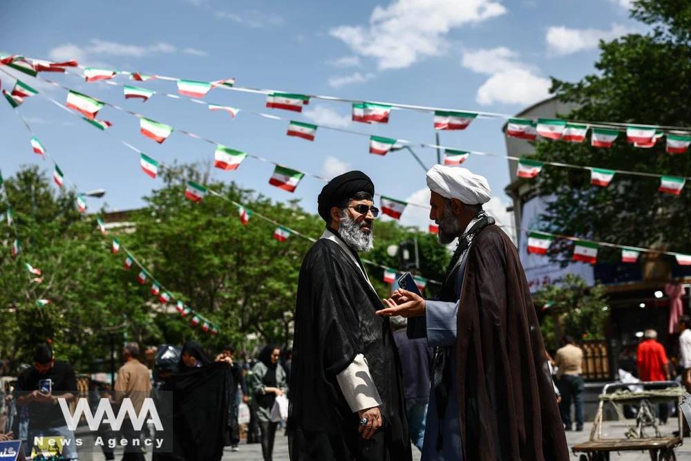 Các giáo sĩ Iran trò chuyện tại chợ Tehran Bazaar ngày 21-4. Ảnh: Majid Asgaripour/WANA