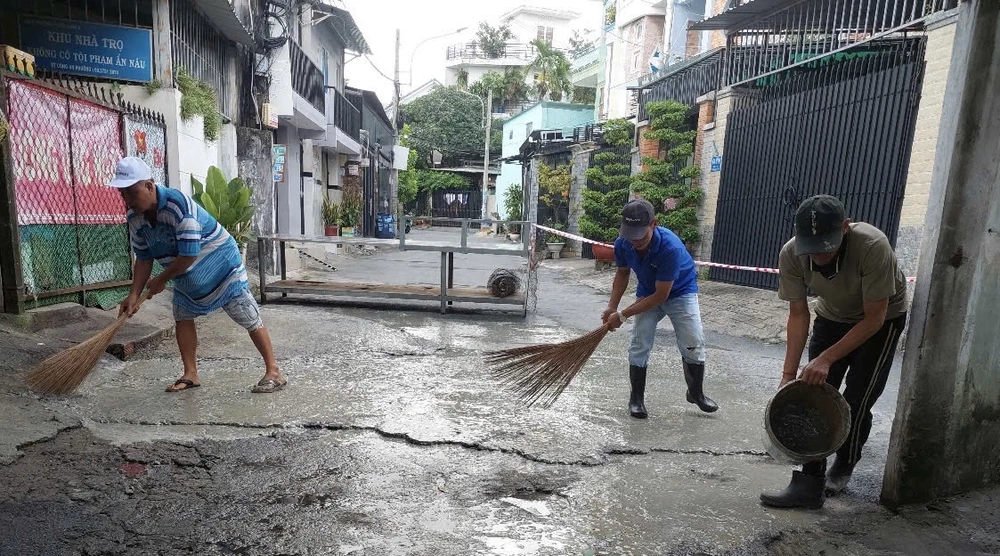 Ông Minh (bên trái) cùng người dân dọn khu phố.