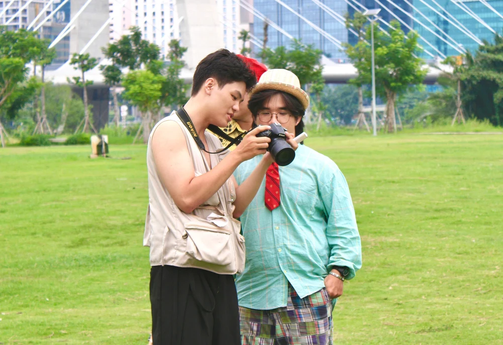 Dưới chân cầu Ba Son, 2 bạn trẻ đang chụp ảnh cho nhau, lưu lại khoảnh khắc đời thường giữa lòng thành phố đang đổi thay. Ảnh: HẢI NHI