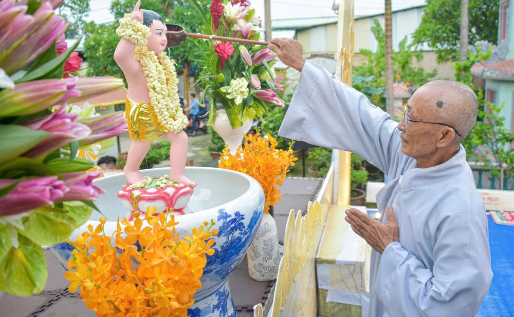 Người dân thực hiện nghi thức tắm Phật tại chùa Long Quang. Ảnh: HẢI NHI